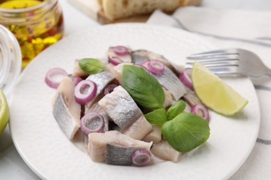 Photo of Plate with tasty marinated fish, onion and basil on light table, closeup