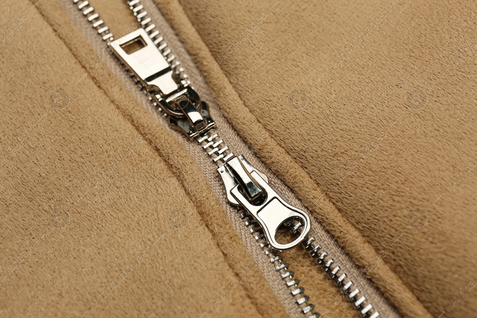 Photo of Beige jacket with zipper as background, closeup view