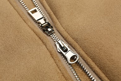 Photo of Beige jacket with zipper as background, closeup view