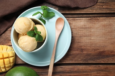 Delicious mango ice cream served on wooden table, flat lay. Space for text