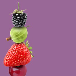 Image of Stack of different fresh tasty berries on pale purple background, space for text