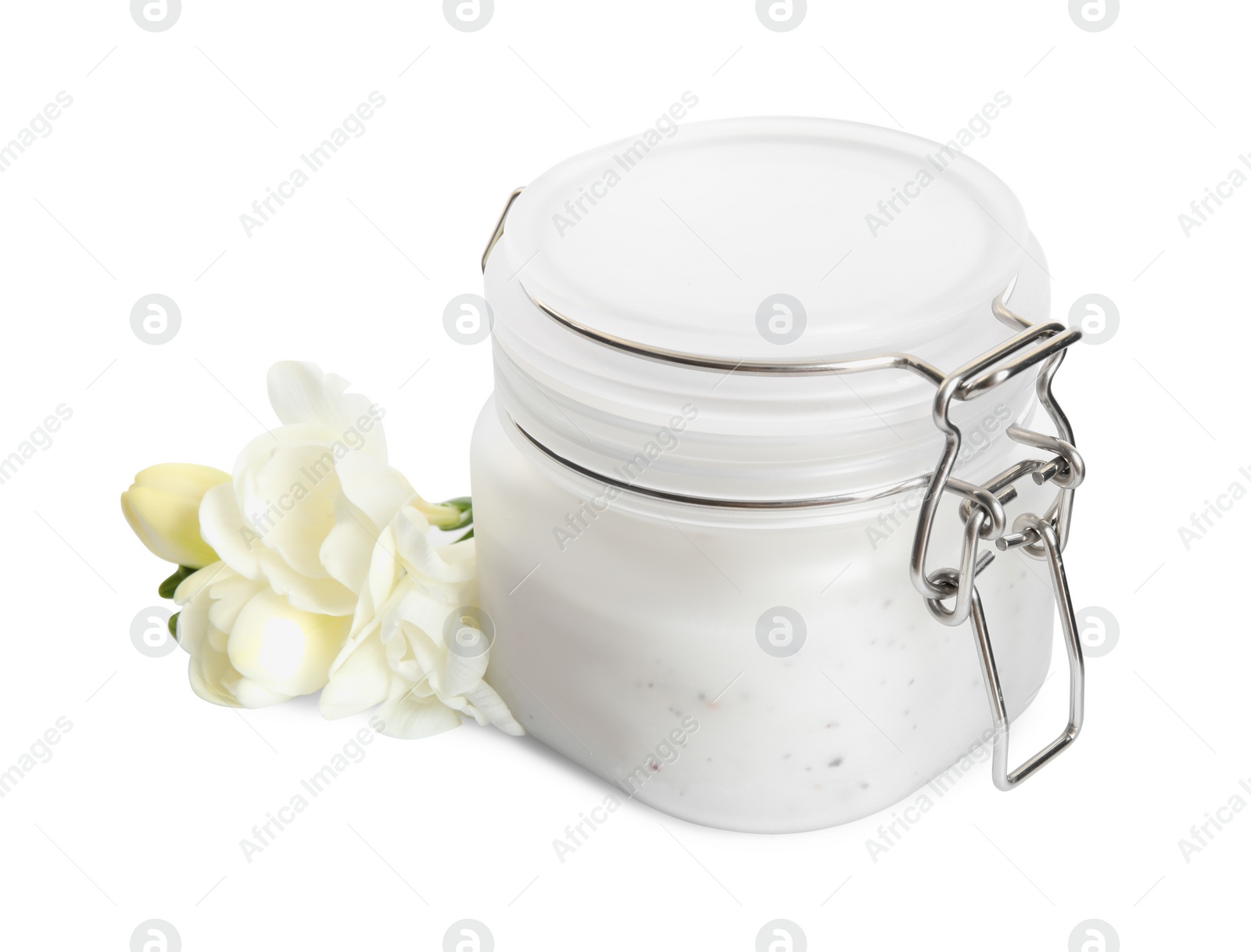 Photo of Jar of exfoliating salt scrub and freesia flowers on white background