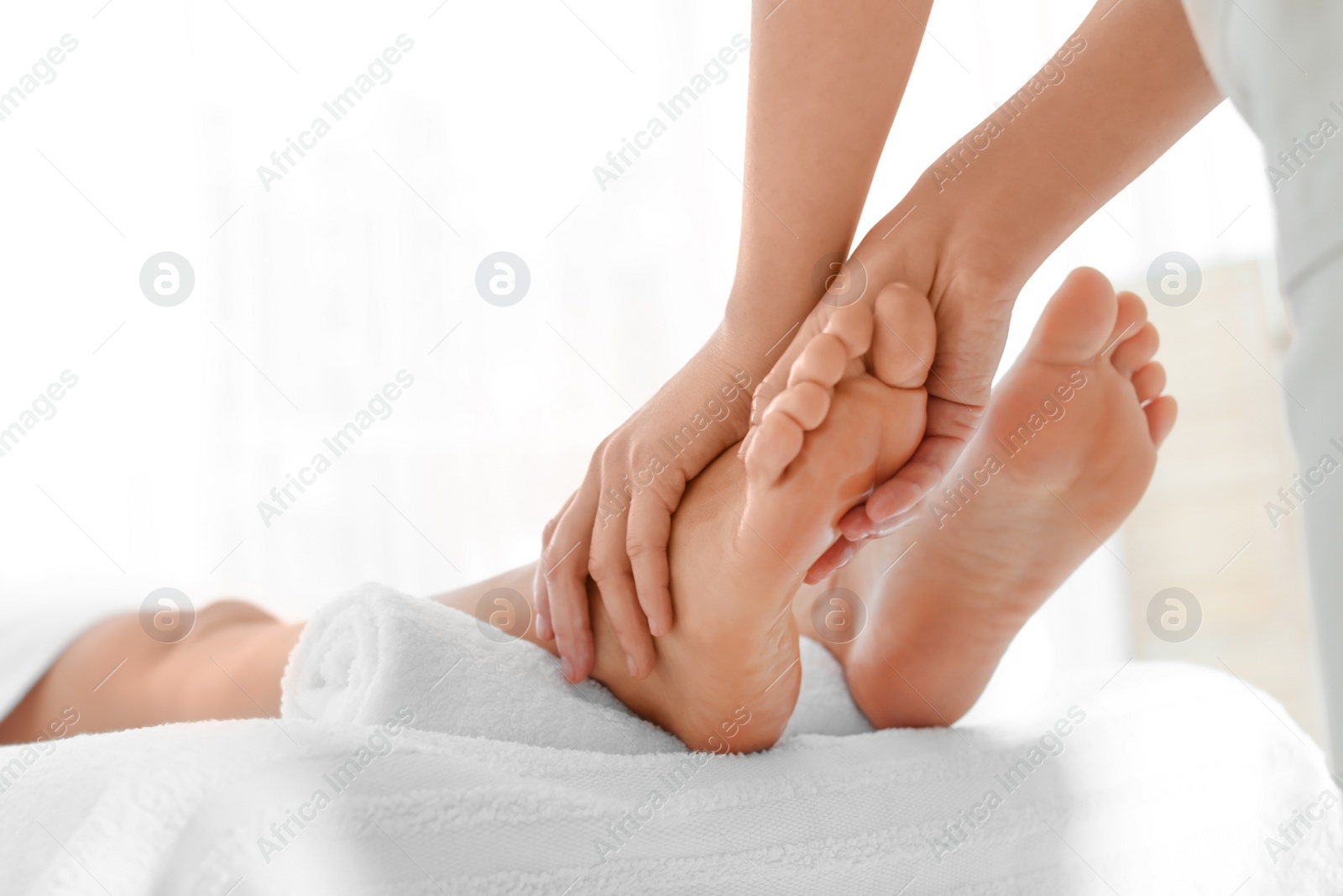 Photo of Woman receiving foot massage in wellness center, closeup