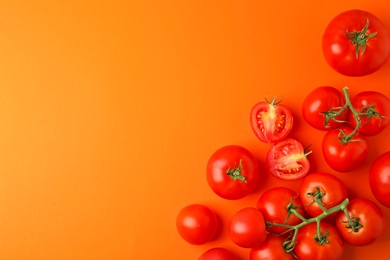 Photo of Flat lay composition with fresh ripe tomatoes on orange background. Space for text
