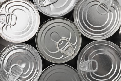Photo of Many closed tin cans as background, top view
