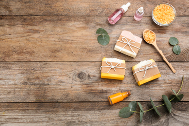 Photo of Flat lay composition with natural handmade soap on wooden background. Space for text
