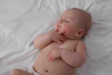 Photo of Cute newborn baby sleeping on bed at home, top view