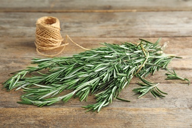 Fresh rosemary branches and twine on wooden table