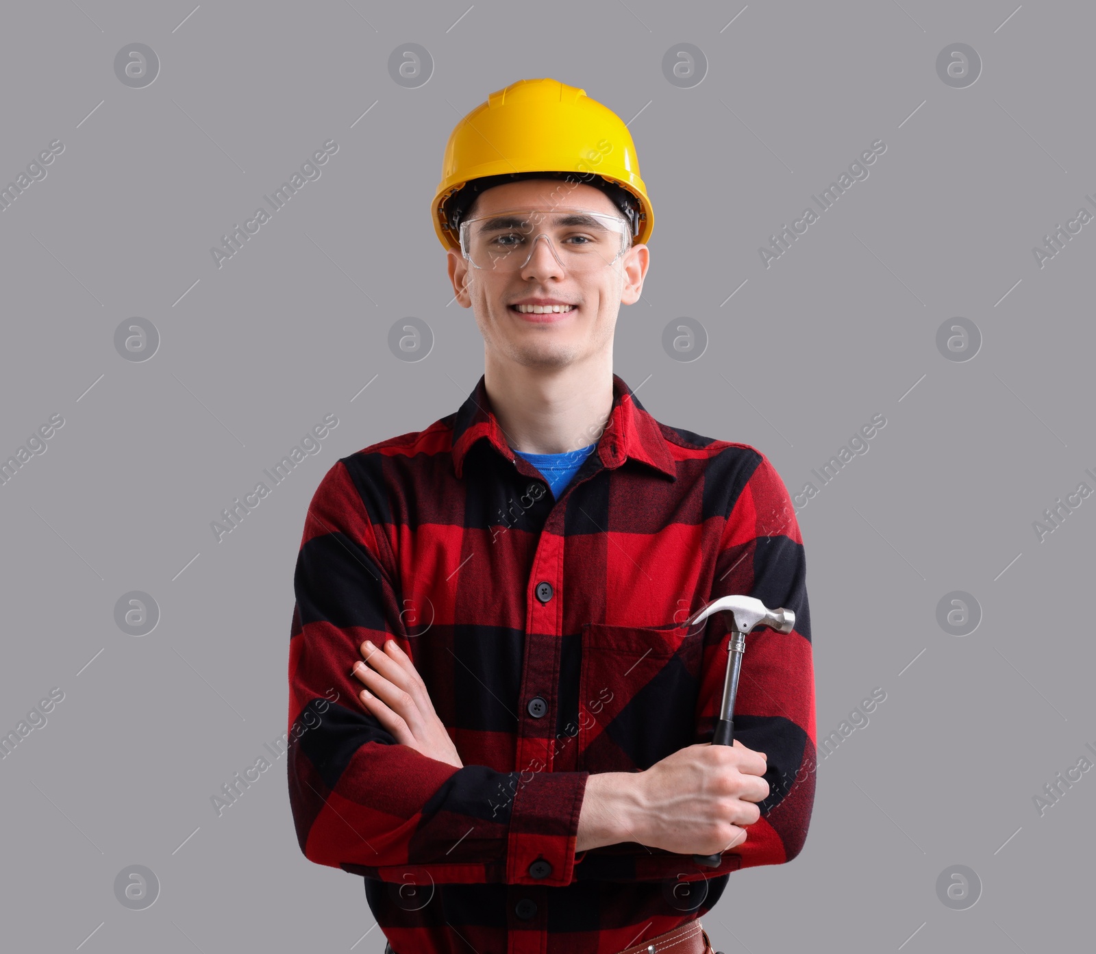 Photo of Professional repairman holding hammer on light grey background