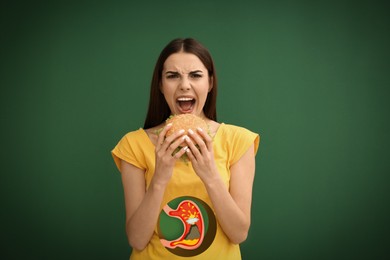 Image of Improper nutrition can lead to heartburn or other gastrointestinal problems. Woman eating burger on green background. Illustration of stomach with erupting volcano as acid indigestion