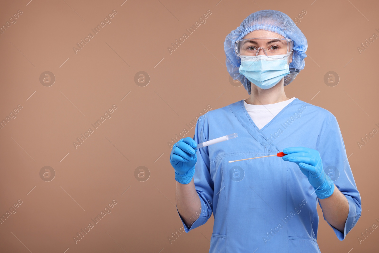 Photo of Laboratory testing. Doctor with cotton swab and tube on light brown background, space for text