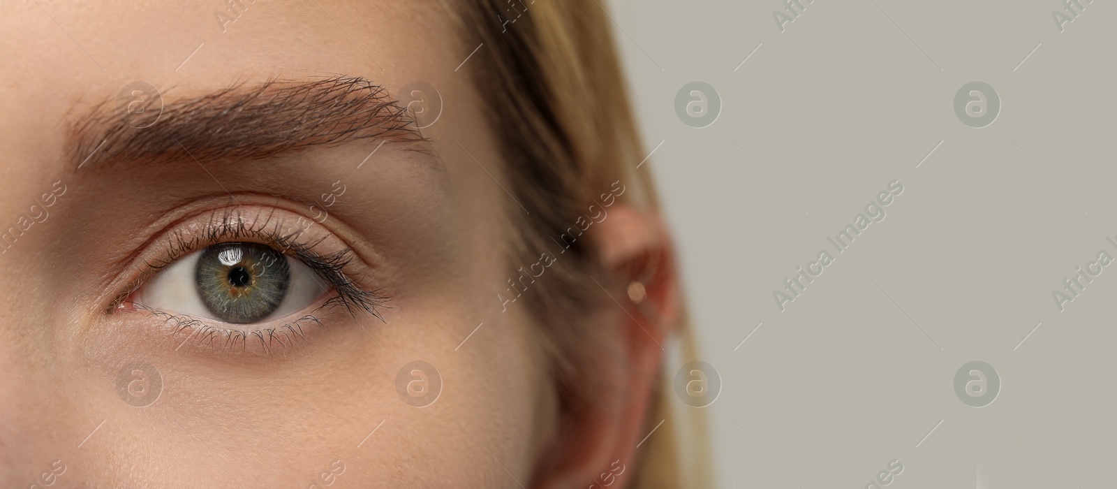 Image of Closeup view of woman with beautiful eyes on light grey background, space for text. Banner design