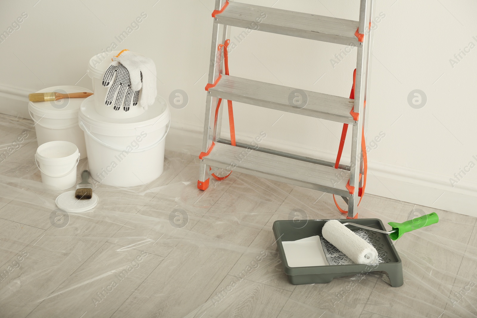 Photo of Stepladder and different tools near wall in room. Interior renovation