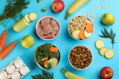 Photo of Pet food and natural ingredients on light blue background, flat lay