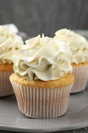 Photo of Tasty cupcakes with vanilla cream on table, closeup