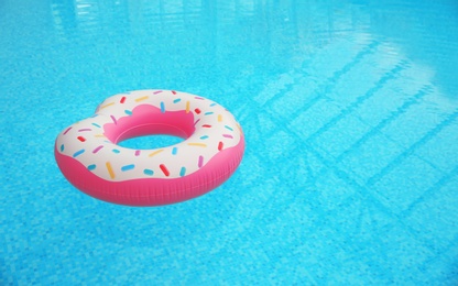 Photo of Inflatable ring floating on water in swimming pool