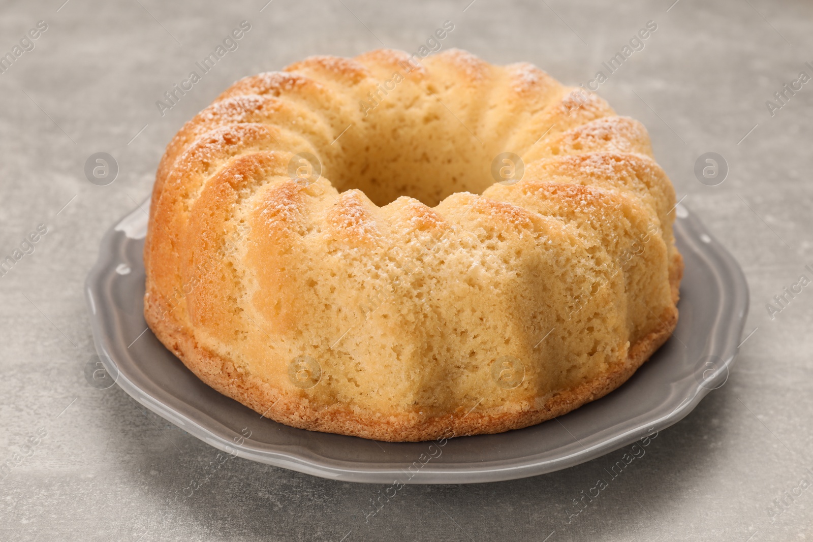 Photo of Delicious freshly baked sponge cake on gray table, closeup