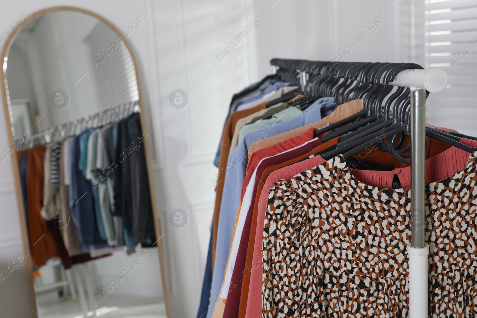 Photo of Rack with stylish clothes indoors. Fast fashion