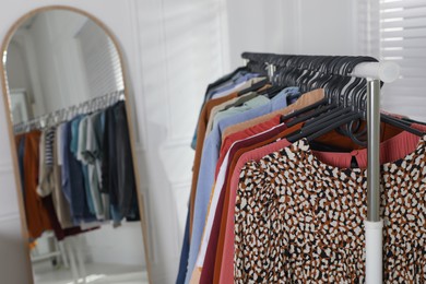 Rack with stylish clothes indoors. Fast fashion