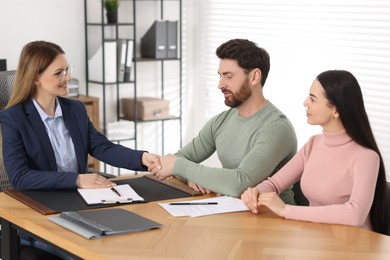 Lawyer shaking hands with clients in office