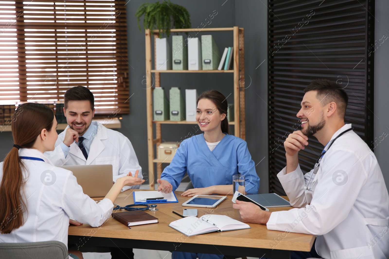 Photo of Team of professional doctors having meeting in office