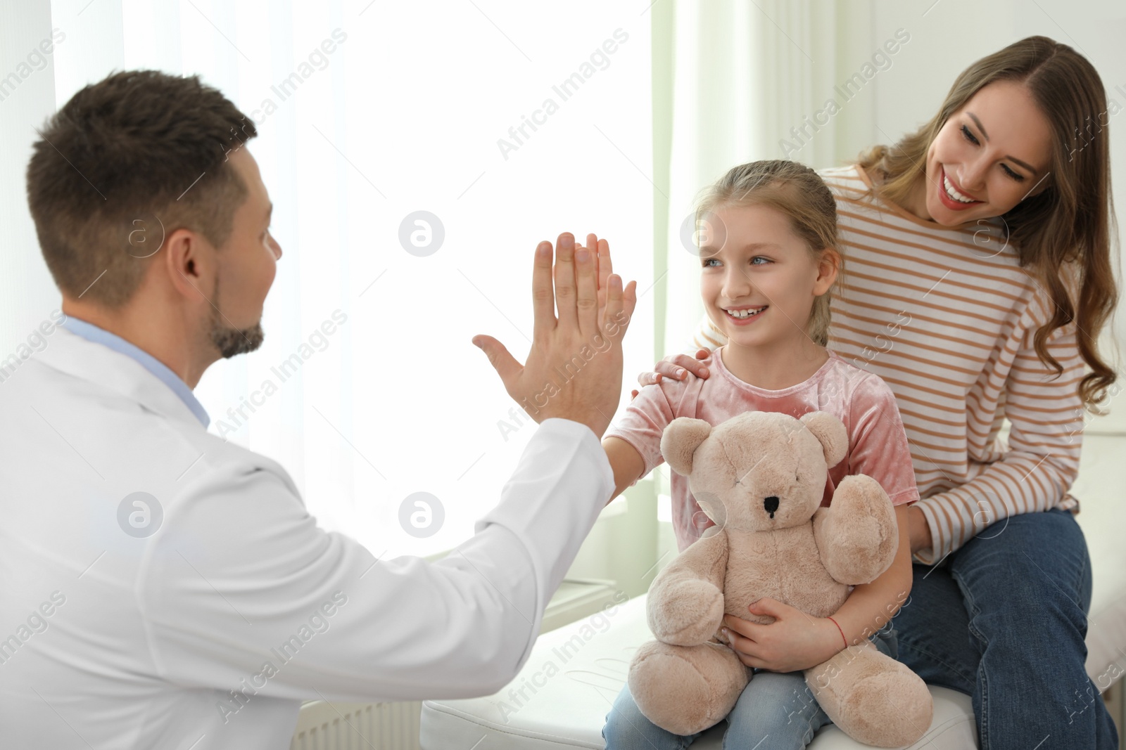 Photo of Mother and daughter visiting pediatrician. Doctor working with patient in hospital