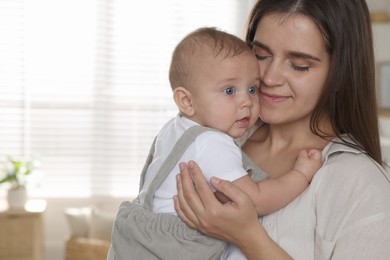 Photo of Happy young mother with her baby at home. Space for text