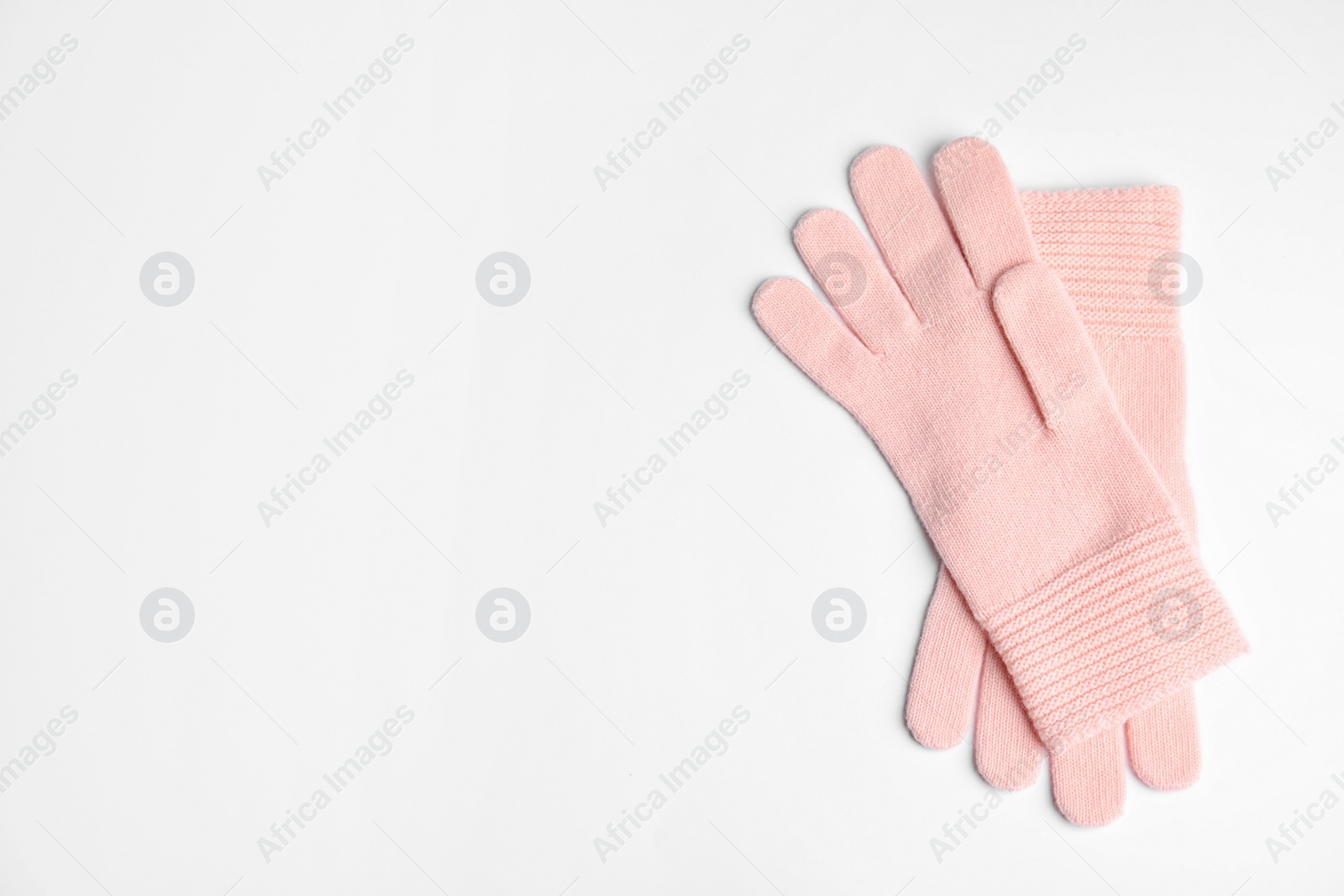 Photo of Stylish pink gloves on white background, top view with space for text. Autumn clothes