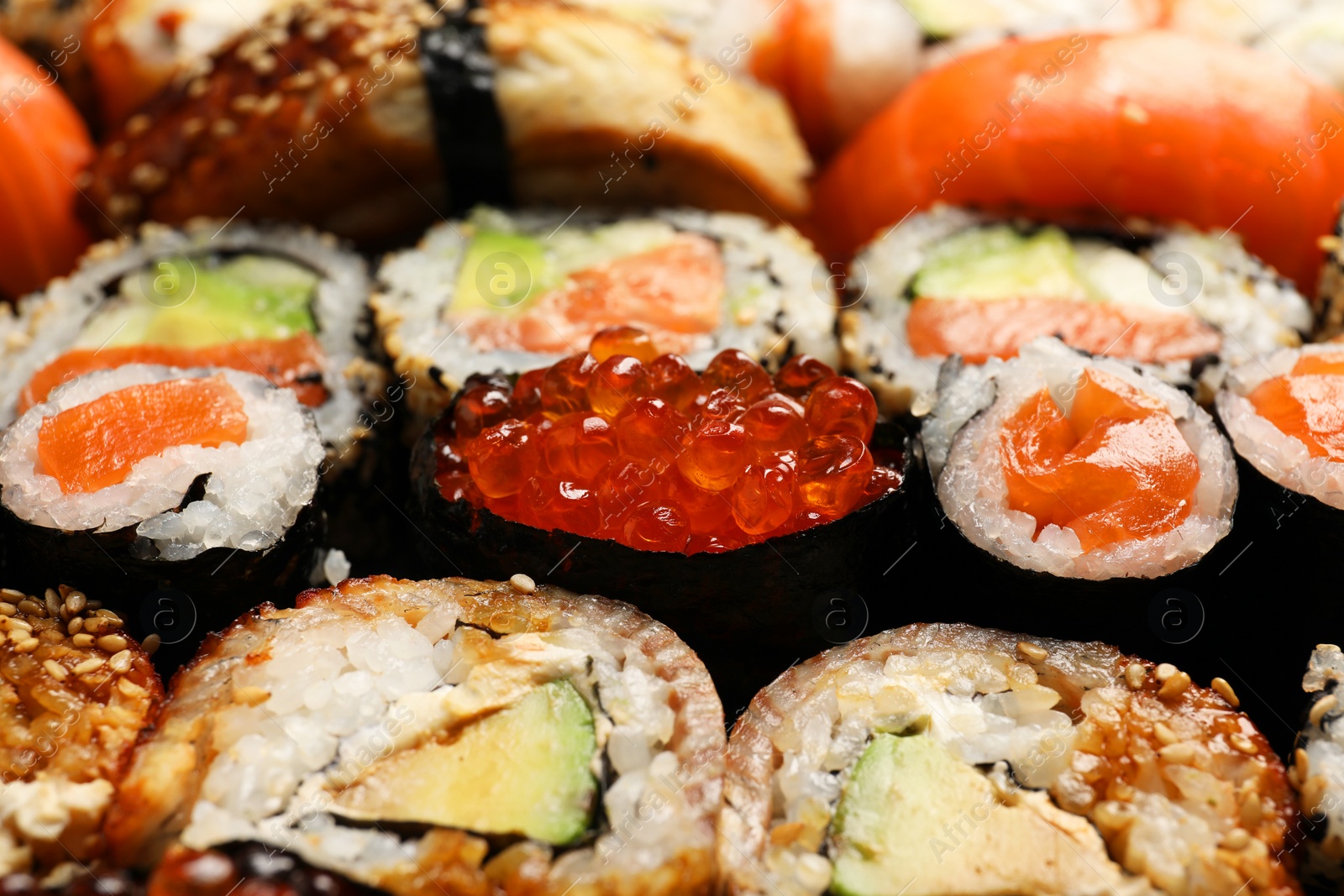 Photo of Different tasty sushi rolls as background, closeup