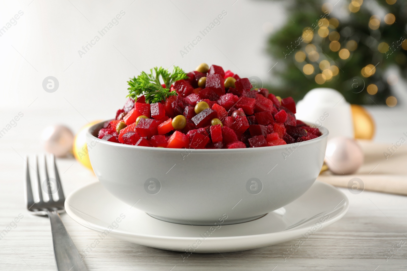 Photo of Traditional Russian salad vinaigrette served on white wooden table