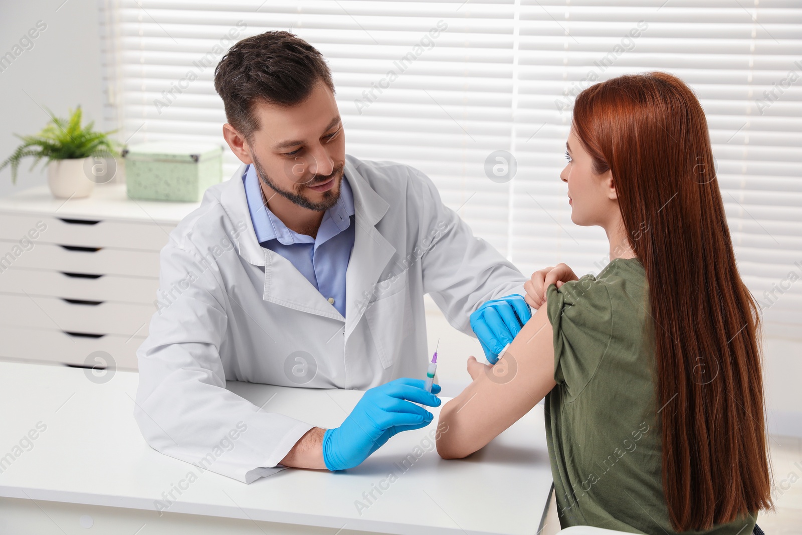 Photo of Doctor giving hepatitis vaccine to patient in clinic