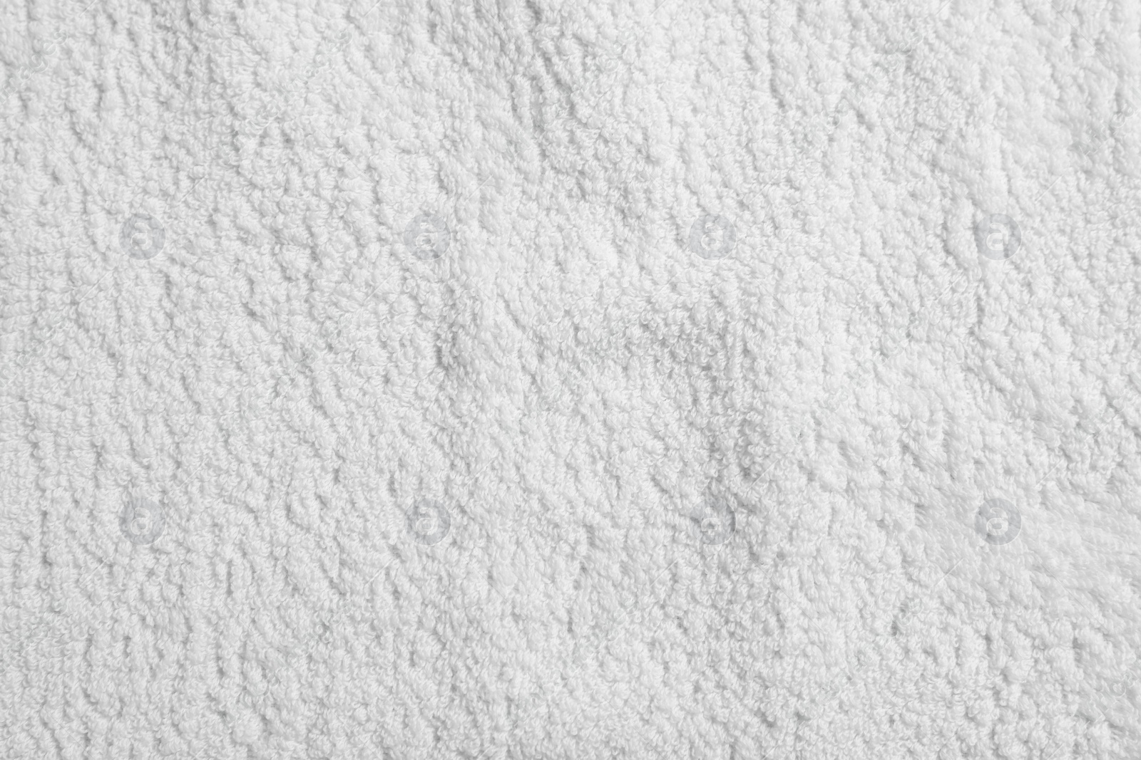 Photo of Texture of soft white towel as background, top view