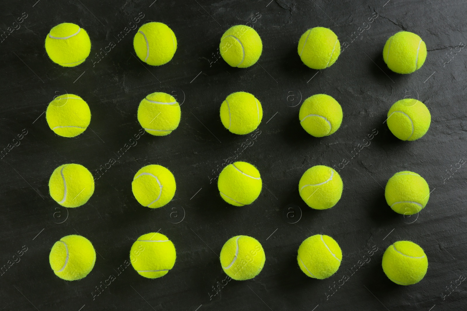 Photo of Tennis balls on black background, flat lay. Sports equipment