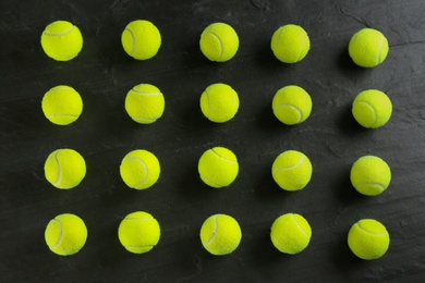 Photo of Tennis balls on black background, flat lay. Sports equipment