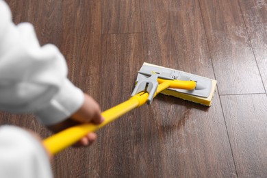 Photo of Woman cleaning parquet floor with mop, above view