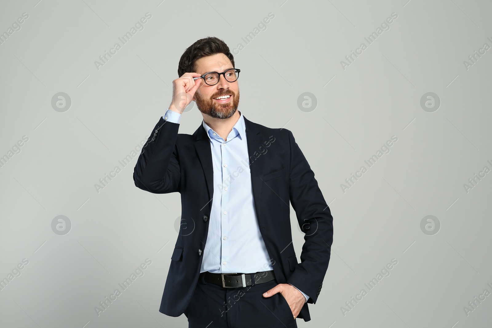 Photo of Handsome real estate agent in nice suit on grey background