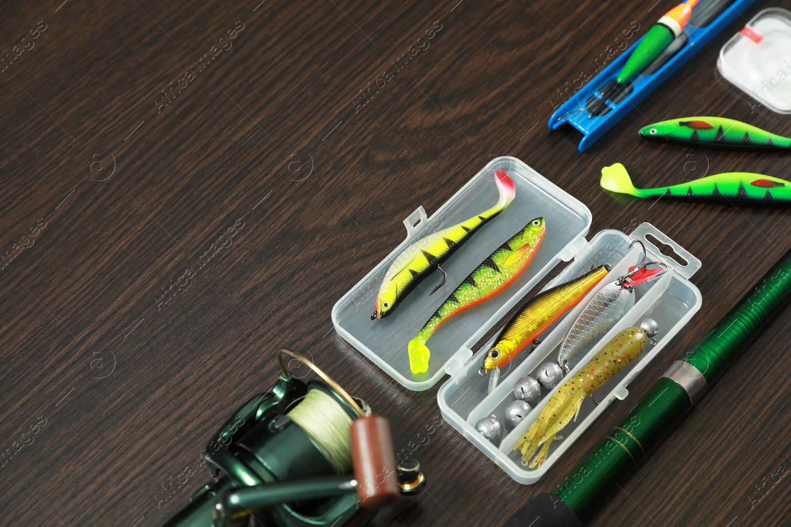 Photo of Fishing tackle on dark wooden background, space for text