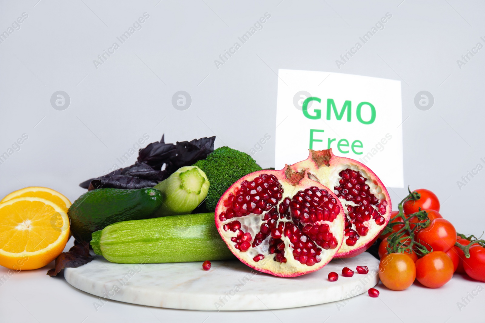 Photo of Tasty fresh GMO free products and paper card on white table