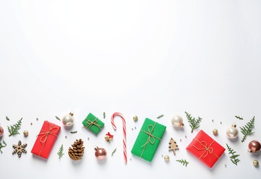 Flat lay composition with Christmas gifts and festive decor on white background. Space for text