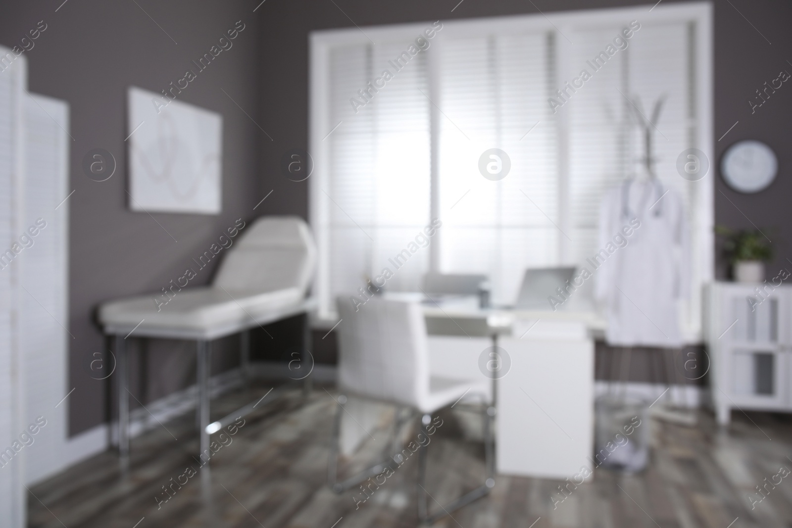 Photo of Blurred view of modern medical office with doctor's workplace. Interior design