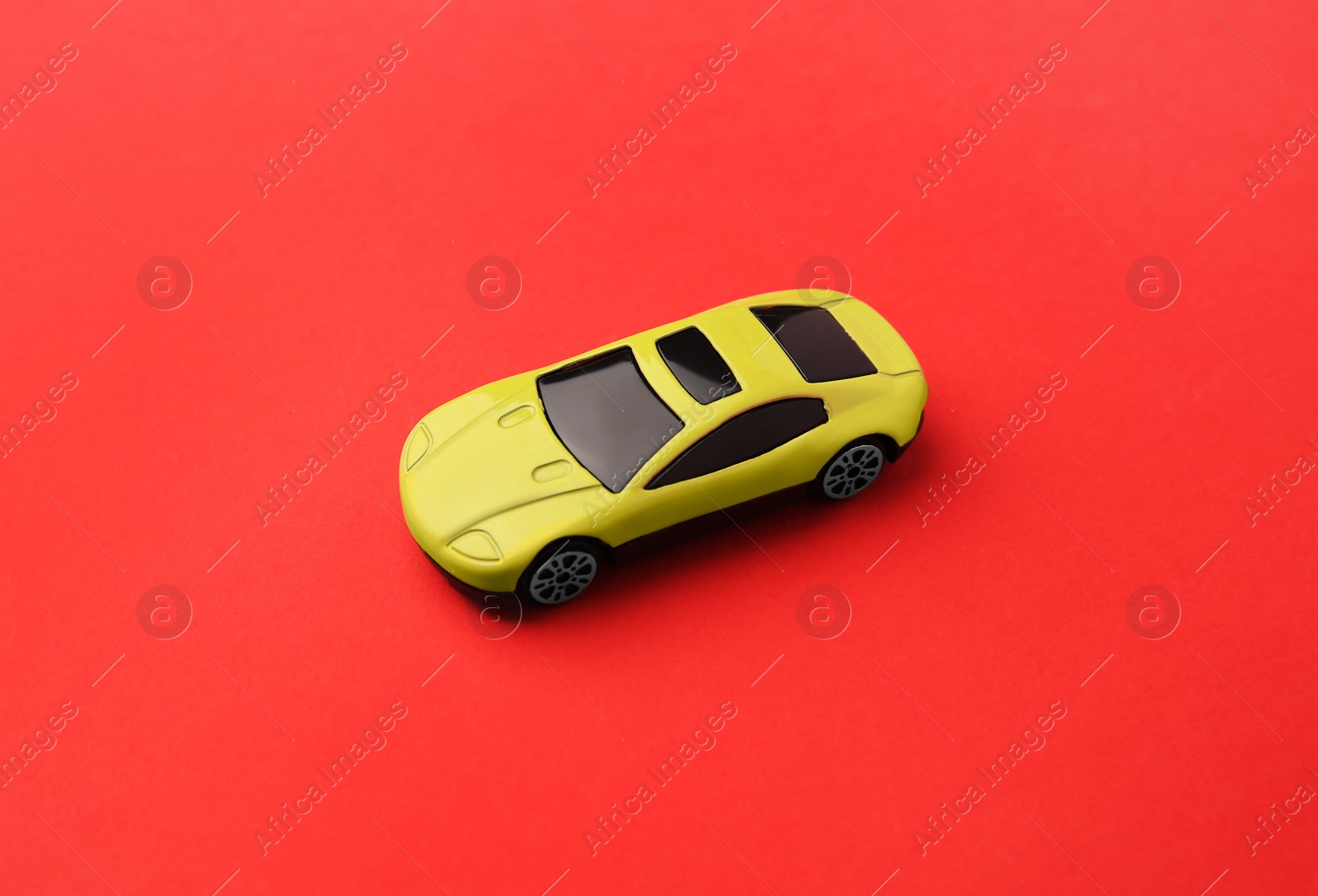 Photo of One yellow car on red background. Children`s toy