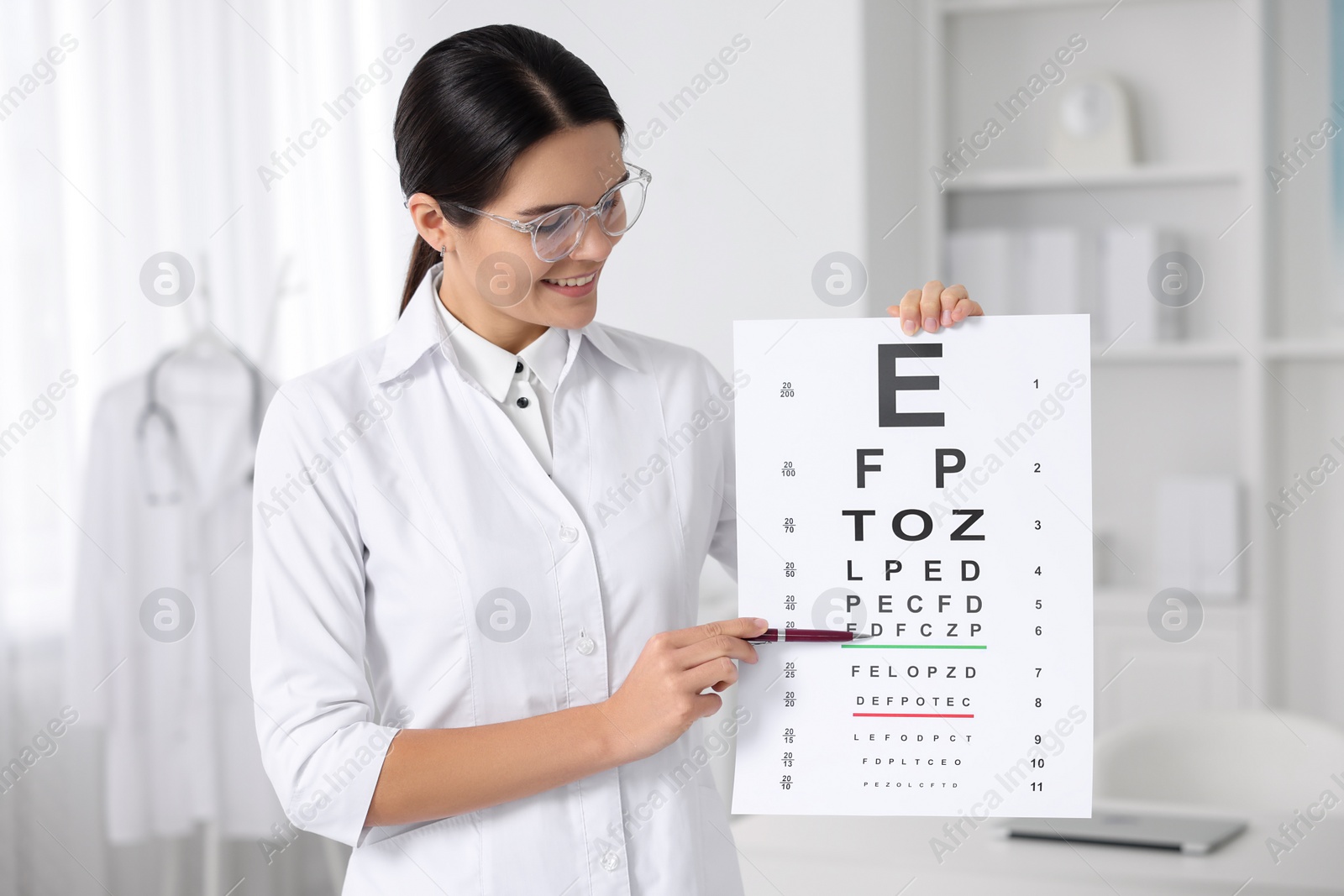 Photo of Ophthalmologist pointing at vision test chart in clinic