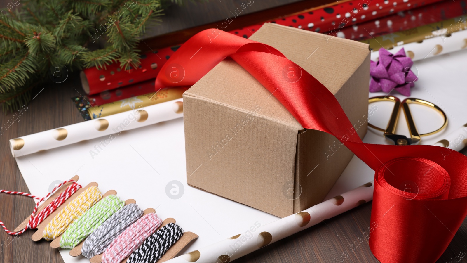 Photo of Box, wrapping paper and scissors on wooden table