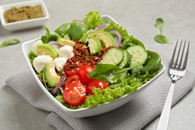 Photo of Delicious avocado salad with quinoa on light grey table