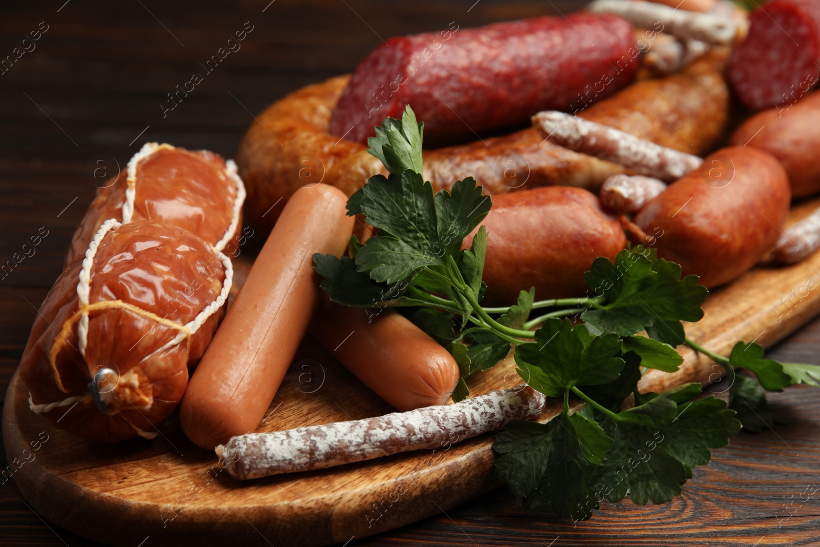 Photo of Different tasty sausages on wooden table, closeup