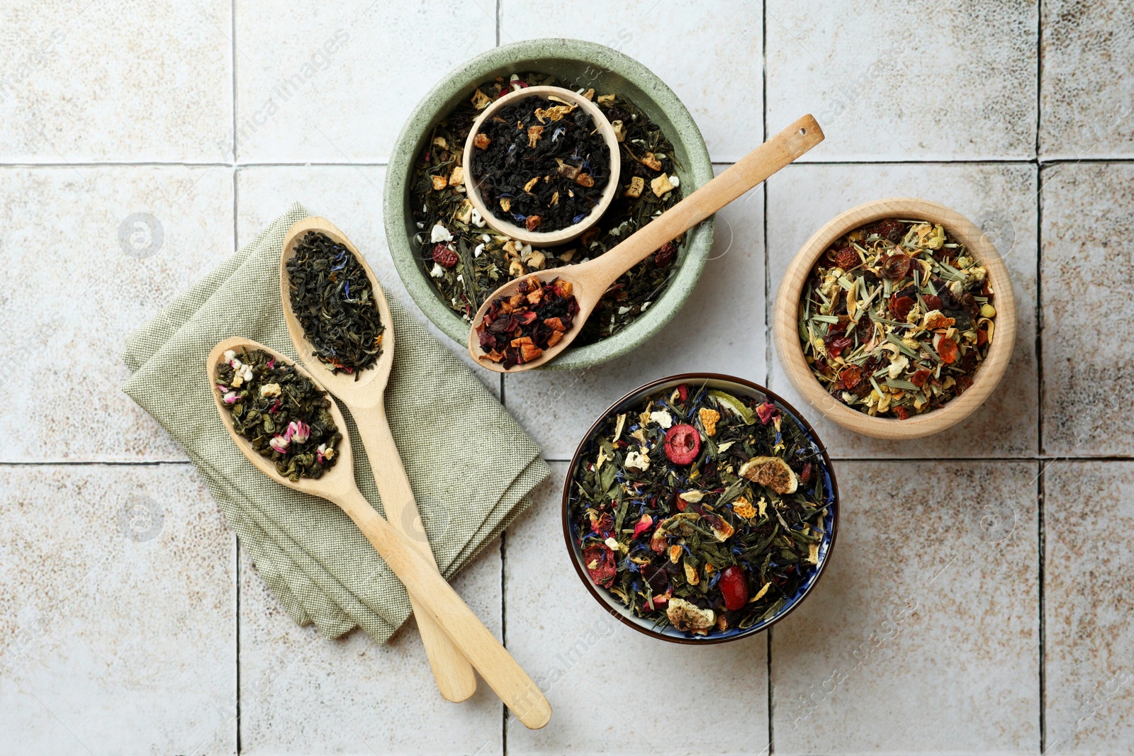 Photo of Many different herbal teas on white tiled surface, flat lay