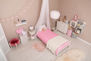 Photo of Cute child's room interior with toys and modern furniture, above view