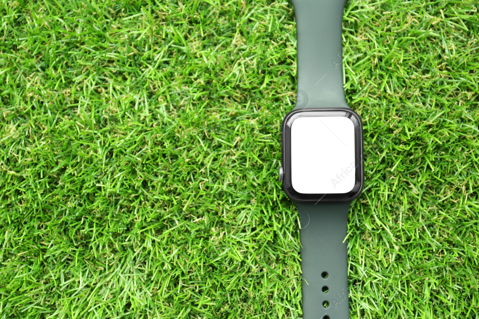 Stylish smart watch on green grass, top view. Space for text Photo of Stylish smart watch on green grass, top view. Space for text