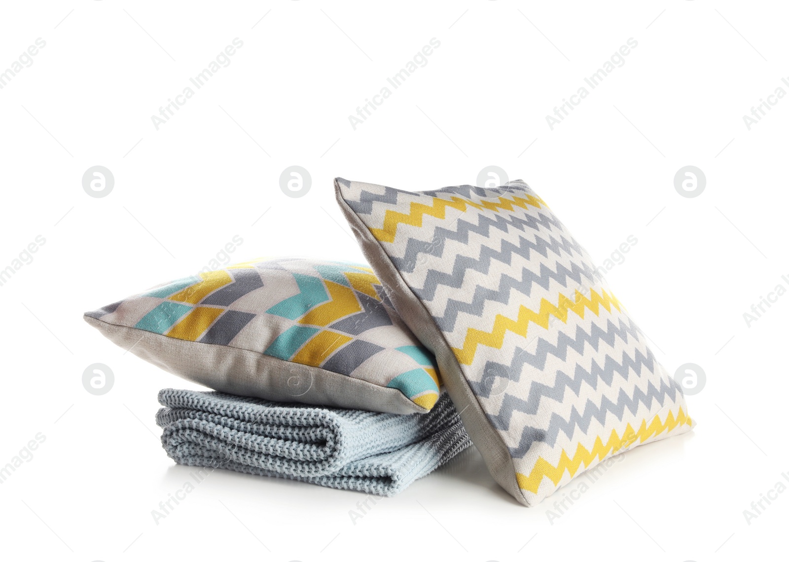 Photo of Stylish soft pillows and folded plaid on white background