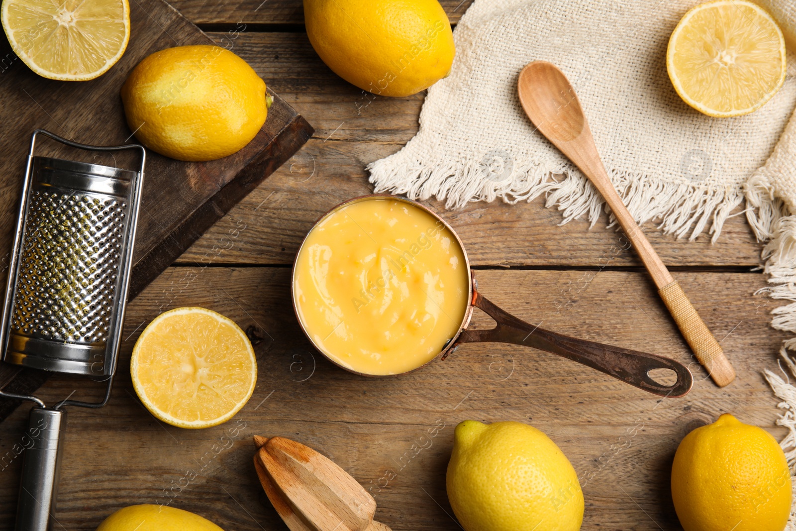 Photo of Delicious lemon curd and fresh fruits on wooden table, flat lay